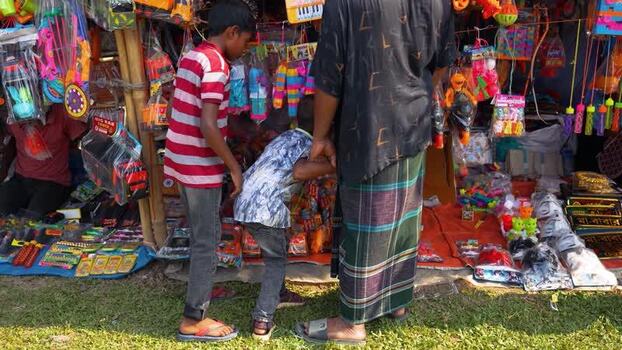 View of people looking at toys at a street market stall Bangladesh. View of people looking at toys at a street market stall Bangladesh.
