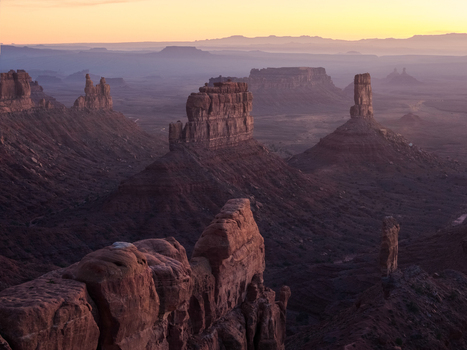 Aerial view of Bears Ears featuring dramatic sandstone buttes and towering rock formations bathed in the warm light of sunrise in San Juan County Utah United States. Aerial view of Bears Ears featuring dramatic sandstone buttes and towering rock formations bathed in the warm light of sunrise in San Juan County Utah United States.