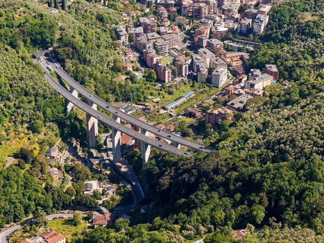 Aerial view of the A12 highway viaduct crossing a lush valley near residential buildings and dense forests in Genova Liguria Italy. Aerial view of the A12 highway viaduct crossing a lush valley near residential buildings and dense forests in Genova Liguria Italy.