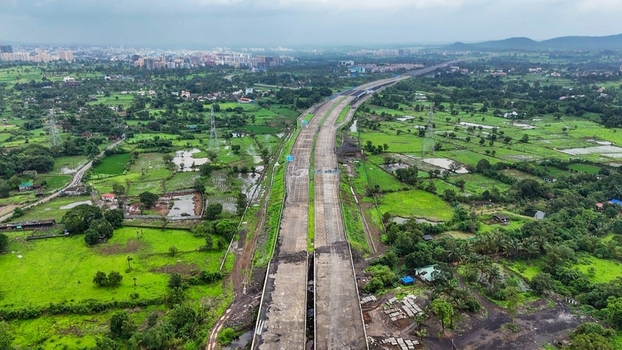 Aerial view of the Delhi Mumbai Expressway stretching through the lush green rural landscape and agricultural fields near Badlapur Maharashtra India. Aerial view of the Delhi Mumbai Expressway stretching through the lush green rural landscape and agricultural fields near Badlapur Maharashtra India.