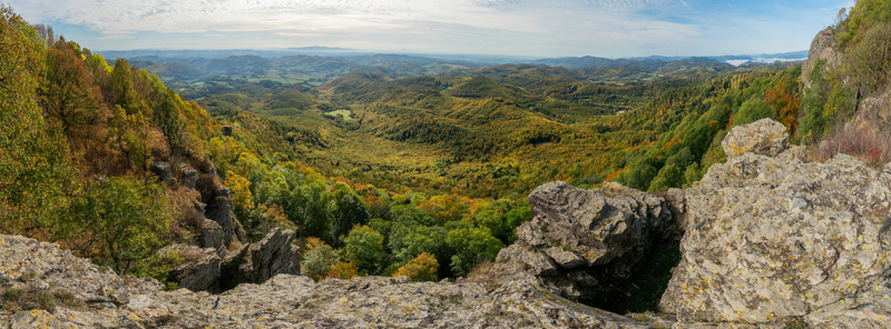 Aerial view of Sitno mountain in Stiavnicke Vrchy featuring rugged rock formations dense autumn forests with vibrant foliage and rolling hills in Ilija Banska Bystrica Regio Slovakia.