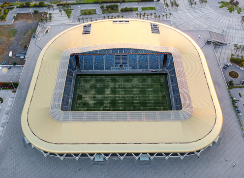 Aerial view of Sammy Ofer Stadium featuring its distinctive golden roof and green pitch in Haifa Haifa District Israel.