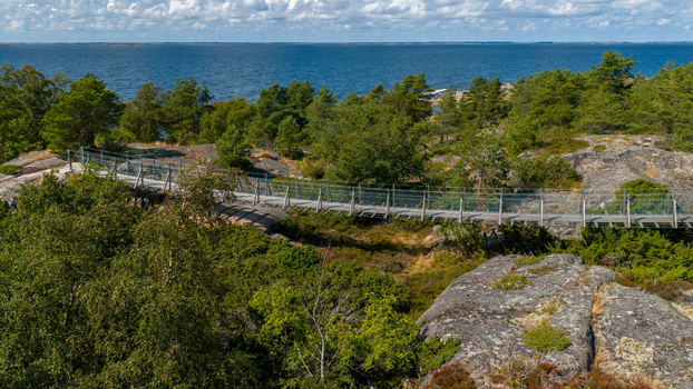 Aerial view of the footbridge at Oro Fortress Island surrounded by rocky terrain lush green forest and the Baltic Sea in Oro Varsinais Suomi Finland. Aerial view of the footbridge at Oro Fortress Island surrounded by rocky terrain lush green forest and the Baltic Sea in Oro Varsinais Suomi Finland.