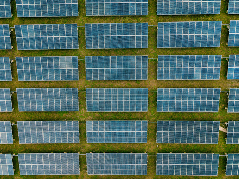 Aerial view of rows of solar panels installed on a grassy field in Ogun State Nigeria.
