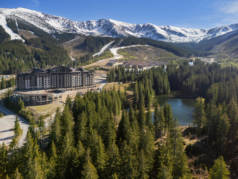 Aerial view of DAMIAN JASNA Hotel Resort Residences surrounded by dense pine forests and snow capped mountain peaks under a clear blue sky Demanovska Dolina Zilinsky kraj Slovakia. Aerial view of DAMIAN JASNA Hotel Resort Residences surrounded by dense pine forests and snow capped mountain peaks under a clear blue sky Demanovska Dolina Zilinsky kraj Slovakia.