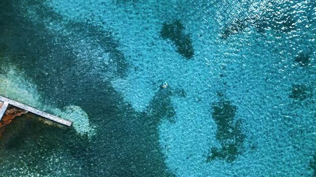 Aerial view of a person swimming in turquoise water Honduras. Aerial view of a person swimming in turquoise water Honduras.