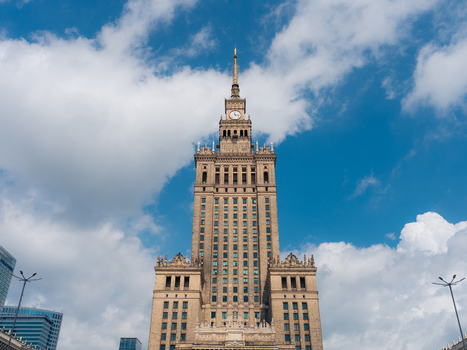 View of the Palace of Culture and Science a historic skyscraper with stone facade and clock tower set against a blue sky with white clouds in Warszawa Mazowieckie Poland. View of the Palace of Culture and Science a historic skyscraper with stone facade and clock tower set against a blue sky with white clouds in Warszawa Mazowieckie Poland.