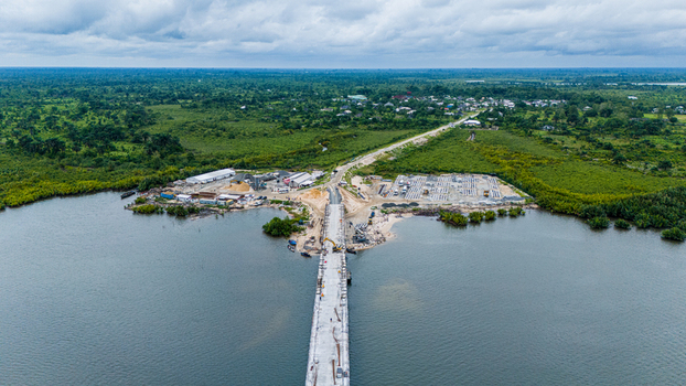 Port Harcourt Nigeria 03 July 2026 Aerial view of a bridge under construction spanning a river with lush vegetation construction equipment and a small settlement in the distance. Port Harcourt Nigeria 03 July 2026 Aerial view of a bridge under construction spanning a river with lush vegetation construction equipment and a small settlement in the distance.