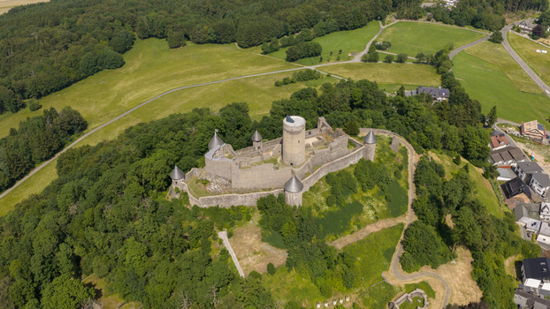 Aerial view of Nurburg Castle surrounded by lush green forests and rolling hills in Nurburg Rhineland Palatinate Germany. Aerial view of Nurburg Castle surrounded by lush green forests and rolling hills in Nurburg Rhineland Palatinate Germany.