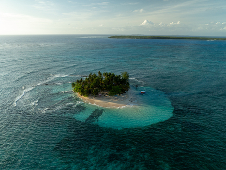 Aerial view of Guyam Island with its lush palm trees and white sand beach surrounded by turquoise waters and coral reefs in General Luna Caraga Philippines. Aerial view of Guyam Island with its lush palm trees and white sand beach surrounded by turquoise waters and coral reefs in General Luna Caraga Philippines.