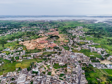 Aerial view of a tapestry of verdant fields and clustered buildings contrasted by the distant shimmer of a vast lake Chakswari Azad Kashmir Pakistan. Aerial view of a tapestry of verdant fields and clustered buildings contrasted by the distant shimmer of a vast lake Chakswari Azad Kashmir Pakistan.