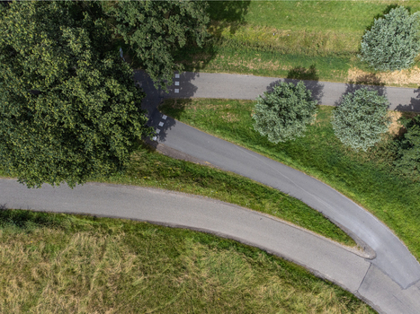 Aerial view of winding asphalt paths converge amidst a vibrant tapestry of green grass and lush trees near Uitkijktoren Hemelrijkse Waard Oijen Noord Brabant Netherlands. Aerial view of winding asphalt paths converge amidst a vibrant tapestry of green grass and lush trees near Uitkijktoren Hemelrijkse Waard Oijen Noord Brabant Netherlands.