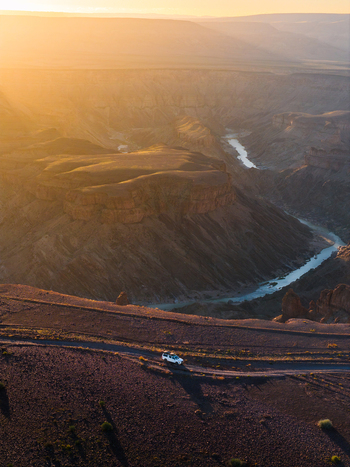 Aerial view of the winding Fish River cutting through the arid landscape bathed in the warm glow of the setting sun Fish River Canyon Karas Region Namibia. Aerial view of the winding Fish River cutting through the arid landscape bathed in the warm glow of the setting sun Fish River Canyon Karas Region Namibia.