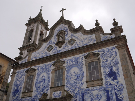 View of the ornate facade of the Church of Santa Maria Maior decorated with traditional blue and white azulejo tiles in Covilha Castelo Branco Portugal. View of the ornate facade of the Church of Santa Maria Maior decorated with traditional blue and white azulejo tiles in Covilha Castelo Branco Portugal.
