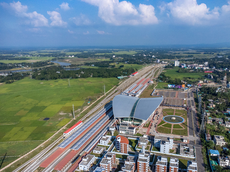 Aerial view of Cox s Bazar Railway Station with its modern curved roof railway tracks lush green fields and urban infrastructure in Cox s Bazar Chittagong Division Bangladesh. Aerial view of Cox s Bazar Railway Station with its modern curved roof railway tracks lush green fields and urban infrastructure in Cox s Bazar Chittagong Division Bangladesh.