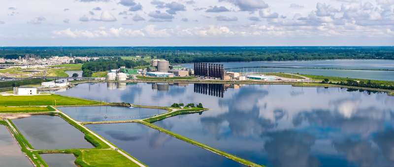 Aerial view of the industrial power plant facility with cooling towers and large water ponds reflecting the cloudy sky in Midland Michigan United States.