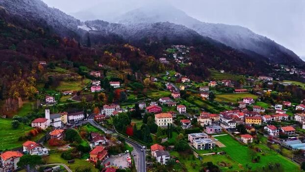 Aerial view of a mountain village with autumn foliage Italy.