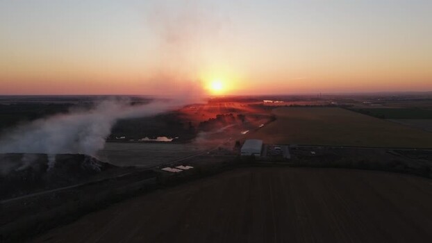 Aerial view of smoke rising over fields at sunset Serbia.
