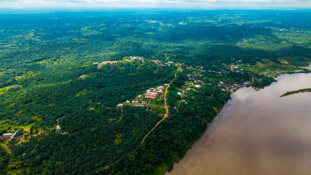 Aerial view of the lush green landscape and winding river flowing past a small settlement in Itu Akwa Ibom Nigeria. Aerial view of the lush green landscape and winding river flowing past a small settlement in Itu Akwa Ibom Nigeria.