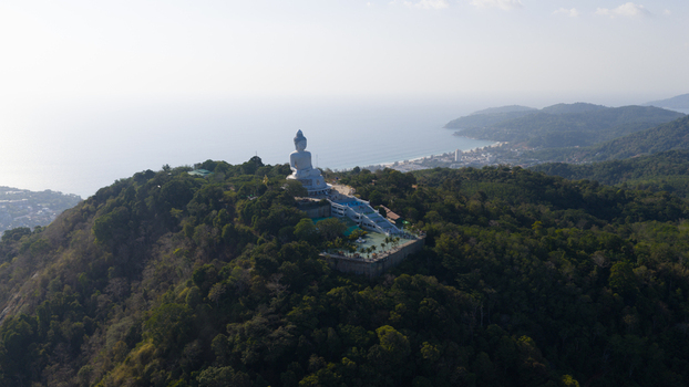 Aerial view of the Big Buddha Phuket statue situated on a lush green hilltop overlooking the Andaman Sea coastline in Karon Phuket Thailand. Aerial view of the Big Buddha Phuket statue situated on a lush green hilltop overlooking the Andaman Sea coastline in Karon Phuket Thailand.