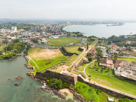 Aerial view of the historic Galle Fort featuring stone ramparts the international cricket stadium and the coastal urban landscape Galle Southern Province Sri Lanka. Aerial view of the historic Galle Fort featuring stone ramparts the international cricket stadium and the coastal urban landscape Galle Southern Province Sri Lanka.