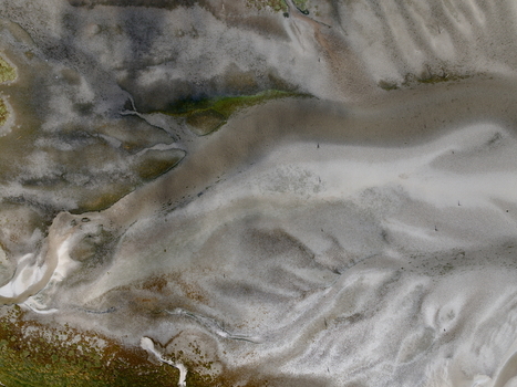 Aerial view of abstract tidal patterns at Culbin Sands showing intricate sand channels water pools and textures along the coastline in Nairn Scotland United Kingdom. Aerial view of abstract tidal patterns at Culbin Sands showing intricate sand channels water pools and textures along the coastline in Nairn Scotland United Kingdom.