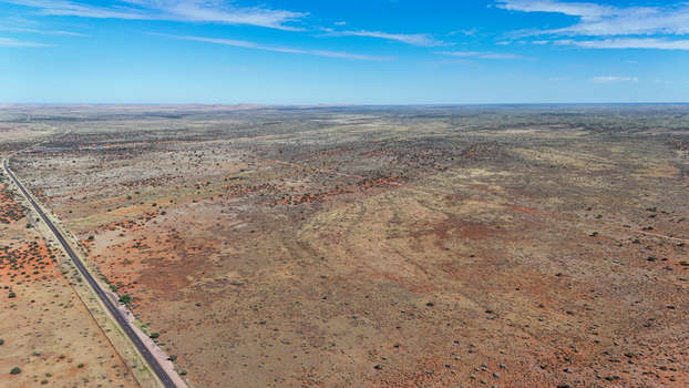 Aerial view of the vast arid landscape stretching out under a clear blue sky the rugged terrain marked by shades of brown and red Karoo Desert Northern Cape South Africa. Aerial view of the vast arid landscape stretching out under a clear blue sky the rugged terrain marked by shades of brown and red Karoo Desert Northern Cape South Africa.