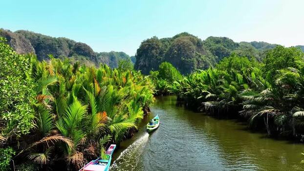 Aerial view of a boat on a river through nipa palms and karst hills Indonesia. Aerial view of a boat on a river through nipa palms and karst hills Indonesia.