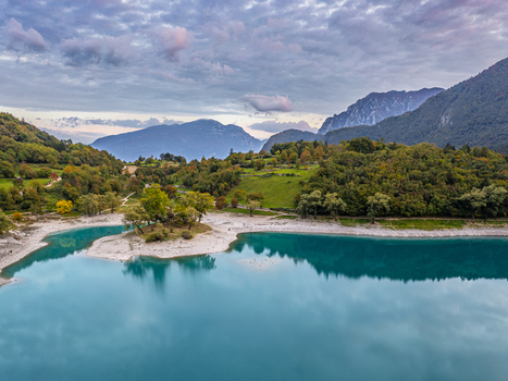Aerial view of Lago di Tenno featuring turquoise waters a small island and autumn forests Tenno Trentino Alto Adige Italy.