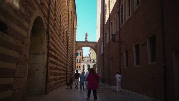 View of people walking in a historic alleyway in Verona Italy. View of people walking in a historic alleyway in Verona Italy.