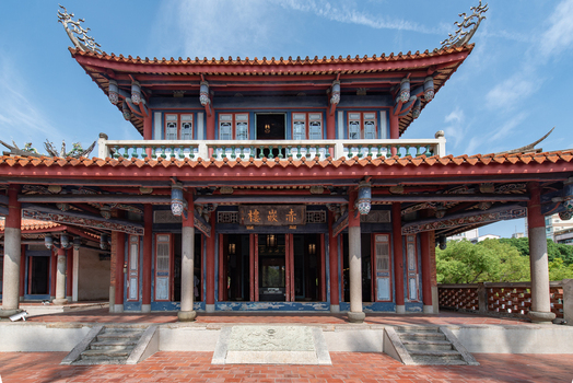 View of Chihkan Tower featuring traditional Chinese architecture with ornate roof red pillars and stone steps under a clear blue sky in Chihkan Village Tainan City Taiwan. View of Chihkan Tower featuring traditional Chinese architecture with ornate roof red pillars and stone steps under a clear blue sky in Chihkan Village Tainan City Taiwan.