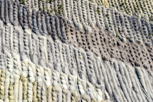 Aerial view of the textured landscape of the Tagebau Welzow Sud brown coal open pit mine showing rows of excavated earth and soil mounds in Spremberg Brandenburg Germany. Aerial view of the textured landscape of the Tagebau Welzow Sud brown coal open pit mine showing rows of excavated earth and soil mounds in Spremberg Brandenburg Germany.