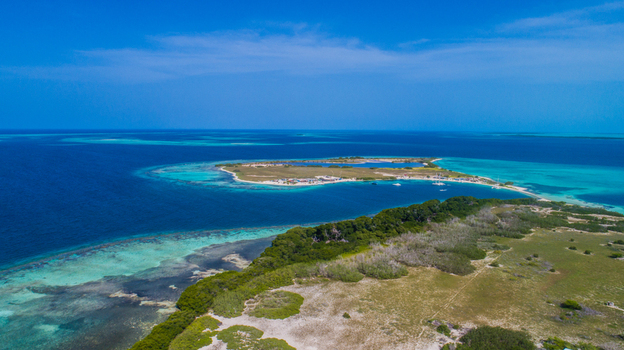 Aerial view of the Los Roques archipelago featuring turquoise waters coral reefs and sandy islands under a clear blue sky in Los Roques Dependencias Federales Venezuela. Aerial view of the Los Roques archipelago featuring turquoise waters coral reefs and sandy islands under a clear blue sky in Los Roques Dependencias Federales Venezuela.
