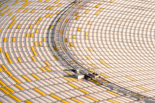 Aerial view of the Polsat Plus Arena roof showing a textured pattern with white and yellow panels intersected by a grey maintenance rail Gdansk Pomeranian Voivodeship Poland. Aerial view of the Polsat Plus Arena roof showing a textured pattern with white and yellow panels intersected by a grey maintenance rail Gdansk Pomeranian Voivodeship Poland.