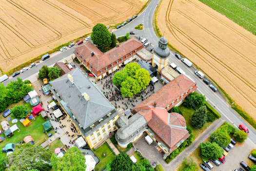 Eggolsheim Germany 09 May 2026 Aerial view of Schloss Jagersburg with its historic architecture inner courtyard filled with people and surrounding golden fields. Eggolsheim Germany 09 May 2026 Aerial view of Schloss Jagersburg with its historic architecture inner courtyard filled with people and surrounding golden fields.