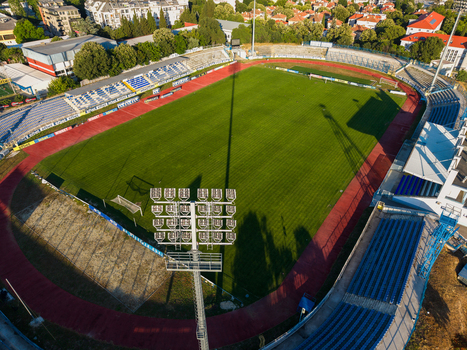 Varna Bulgaria 23 June 2026 Aerial view of Spartak Stadium with its green pitch running track and surrounding seating areas under a clear sky.