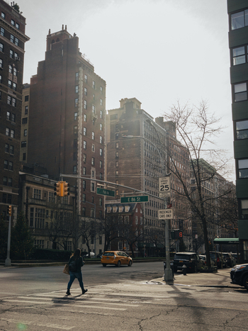 New York United States 13 April 2015 View of a pedestrian crossing at Park Avenue and East 86th Street with a yellow taxi and tall brick buildings in New York City.