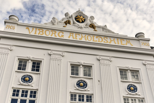Viborg Denmark 07 August 2026 View of the historic Viborg Afholdshiem building featuring a white facade with ornate gold lettering and decorative medallions under a cloudy sky. Viborg Denmark 07 August 2026 View of the historic Viborg Afholdshiem building featuring a white facade with ornate gold lettering and decorative medallions under a cloudy sky.