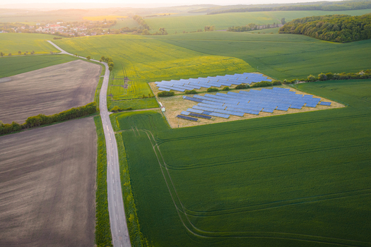 Aerial view of a solar panel farm nestled among lush green agricultural fields and a rural road in Chvalkovice Hradec Kralove Region Czechia.