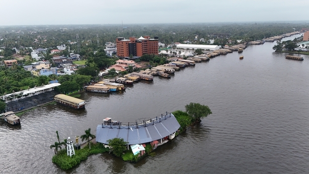 Aerial view of the Nehru Trophy Boat Race Finishing Point Stadium surrounded by numerous houseboats moored along the Punnamada Lake in Alappuzha Kerala India.