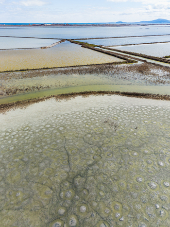 Aerial view of the colorful salt evaporation basins and circular patterns in the shallow waters of Lake Atanasovsko Burgas Burgas Bulgaria. Aerial view of the colorful salt evaporation basins and circular patterns in the shallow waters of Lake Atanasovsko Burgas Burgas Bulgaria.