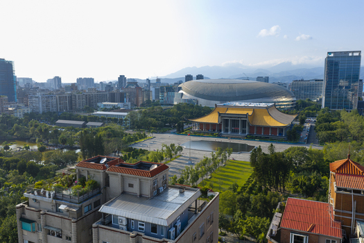 Aerial view of the Sun Yat sen Memorial Hall with its iconic yellow roof and reflecting pool set amidst the urban landscape and Taipei Dome in Taipei Taiwan. Aerial view of the Sun Yat sen Memorial Hall with its iconic yellow roof and reflecting pool set amidst the urban landscape and Taipei Dome in Taipei Taiwan.