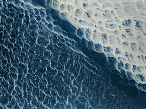 Aerial view of braided glacial rivers carving through stark contrasting landscapes a mesmerizing dance of dark waters against pale earth Iceland. Aerial view of braided glacial rivers carving through stark contrasting landscapes a mesmerizing dance of dark waters against pale earth Iceland.
