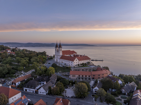Aerial view of Tihany Abbey overlooking Lake Balaton at sunset with historic red tiled rooftops and calm water in Tihany Hungary. Aerial view of Tihany Abbey overlooking Lake Balaton at sunset with historic red tiled rooftops and calm water in Tihany Hungary.