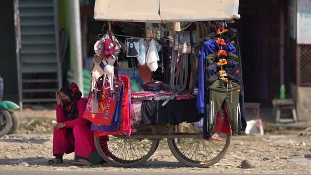 View of a street vendor cart with clothes and a woman Nepal. View of a street vendor cart with clothes and a woman Nepal.