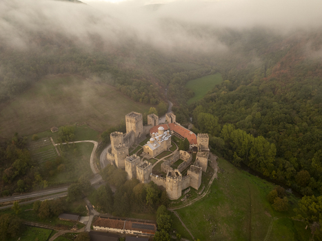 Aerial view of Manasija Monastery a medieval fortified Eastern Orthodox monastery surrounded by lush green forests and rolling hills under a misty sky in Despotovac Pomoravski okrug Serbia.