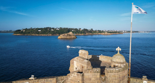 Aerial view of a medieval stone fortress of chateau du Taureau overlooking a tranquil sea with distant islands under a clear sky Plouezoc h Bretagne France. Aerial view of a medieval stone fortress of chateau du Taureau overlooking a tranquil sea with distant islands under a clear sky Plouezoc h Bretagne France.