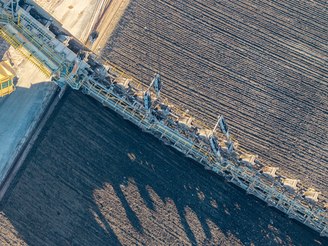 Aerial view of the Tagebau Welzow Sud brown coal open pit mine with a massive bucket wheel excavator operating on dark soil in Spremberg Brandenburg Germany. Aerial view of the Tagebau Welzow Sud brown coal open pit mine with a massive bucket wheel excavator operating on dark soil in Spremberg Brandenburg Germany.
