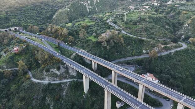 Aerial view of a highway viaduct and tunnels in the hills Italy.