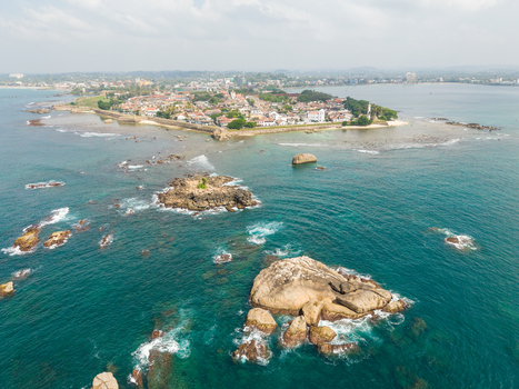 Aerial view of the historic Galle Fort and its surrounding stone walls overlooking rocky outcrops in the turquoise Indian Ocean in Galle Southern Province Sri Lanka. Aerial view of the historic Galle Fort and its surrounding stone walls overlooking rocky outcrops in the turquoise Indian Ocean in Galle Southern Province Sri Lanka.
